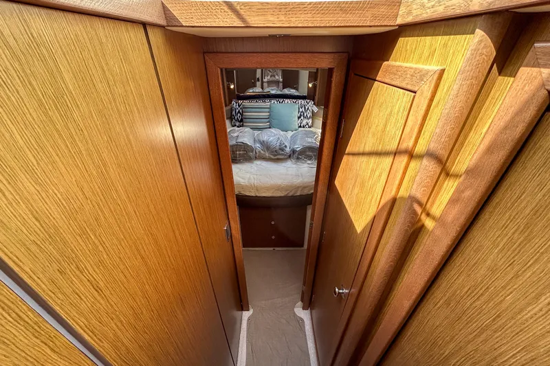 Yacht Photos Pics 2015 Meridian 441 Sedan interior hallway leading to cozy bedroom with wooden paneling.