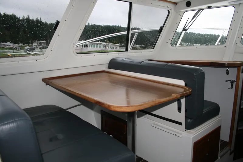 Catcher Yacht Photos Pics Interior of 2019 Ocean Sport Roamer 30, featuring a wooden table and cushioned seating.