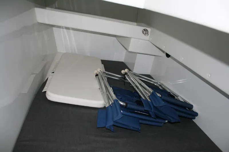 Catcher Yacht Photos Pics Interior storage area of 2019 Ocean Sport Roamer 30, featuring folded chairs and a table.