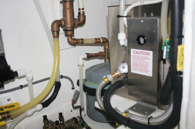 Catcher Yacht Photos Pics Engine room of 2019 Ocean Sport Roamer 30 #117 with plumbing and caution sign.