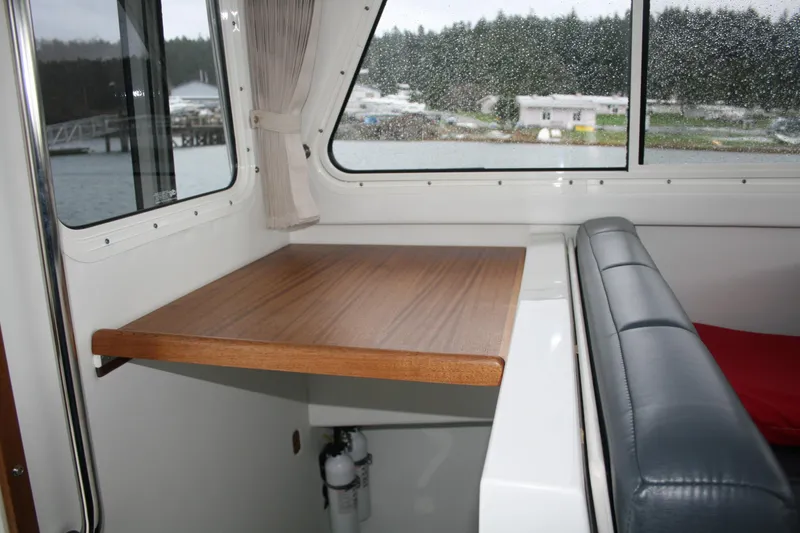 Catcher Yacht Photos Pics Interior of 2019 Ocean Sport Roamer 30, featuring a wooden table and cushioned seating.
