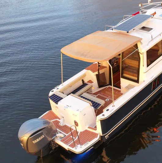  Yacht Photos Pics 2022 Ranger Tugs R-27 boat with Yamaha motor, solar panels, and canopy on calm water.