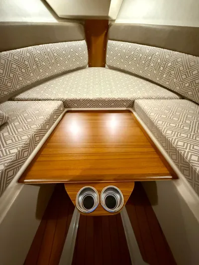  Yacht Photos Pics 2022 Ranger Tugs R-27 cabin interior with patterned cushions and wooden table.