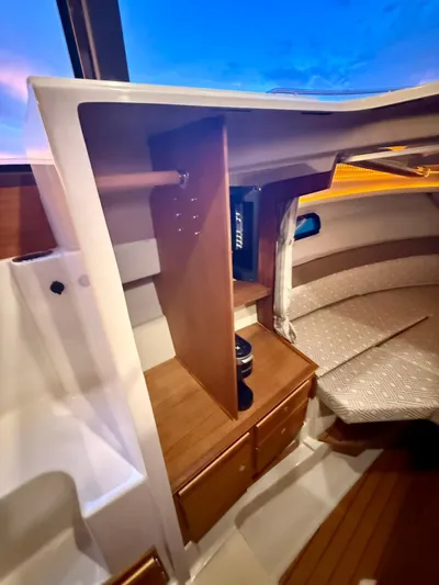  Yacht Photos Pics Interior of 2022 Ranger Tugs R-27 boat with wooden cabinetry and cozy seating area.