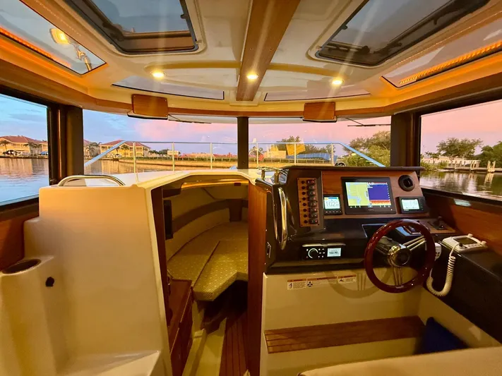  Yacht Photos Pics Interior of 2022 Ranger Tugs R-27 boat with modern navigation equipment and cozy seating.