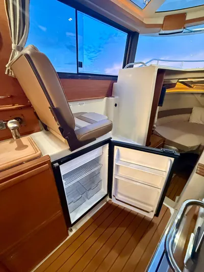  Yacht Photos Pics Interior of 2022 Ranger Tugs R-27 boat with open fridge and seating area.