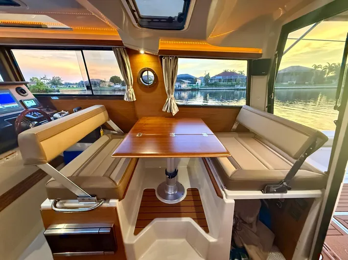  Yacht Photos Pics Interior of 2022 Ranger Tugs R-27, featuring a cozy dining area with sunset view.