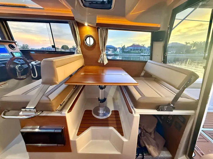  Yacht Photos Pics Interior of 2022 Ranger Tugs R-27 boat with seating and table, sunset view.