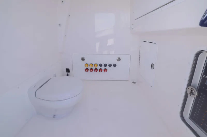 Yacht Photos Pics Interior of 2025 Invincible 35 Catamaran featuring a compact marine toilet and control panel.