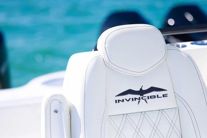  Yacht Photos Pics White leather seat on 2025 Invincible 35 Catamaran, featuring logo and ocean backdrop.