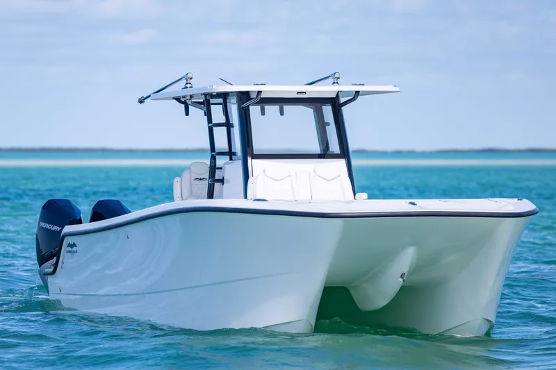  Yacht Photos Pics 2025 Invincible 35 Catamaran on clear blue water, showcasing sleek design and twin Mercury engines.