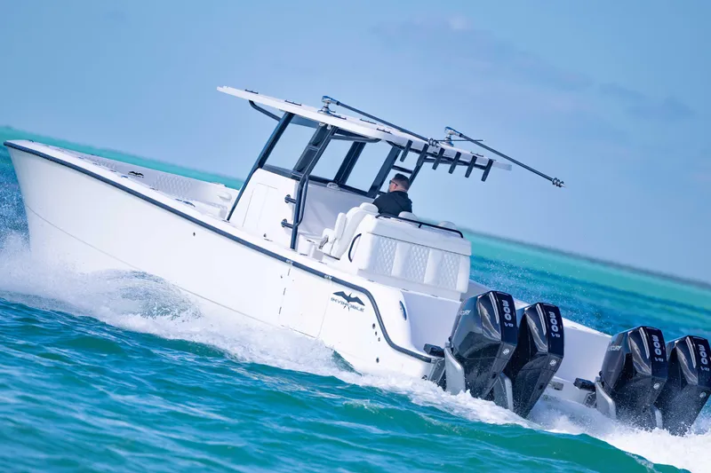  Yacht Photos Pics 2025 Invincible 35 Catamaran cruising on turquoise waters, featuring powerful outboard engines.