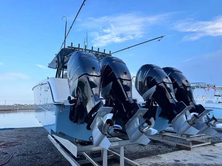  Yacht Photos Pics 2022 Invincible 40 Catamaran with four powerful outboard engines, docked by the water.