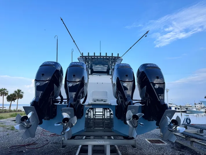  Yacht Photos Pics 2022 Invincible 40 Catamaran with four powerful outboard engines, docked by the shore.