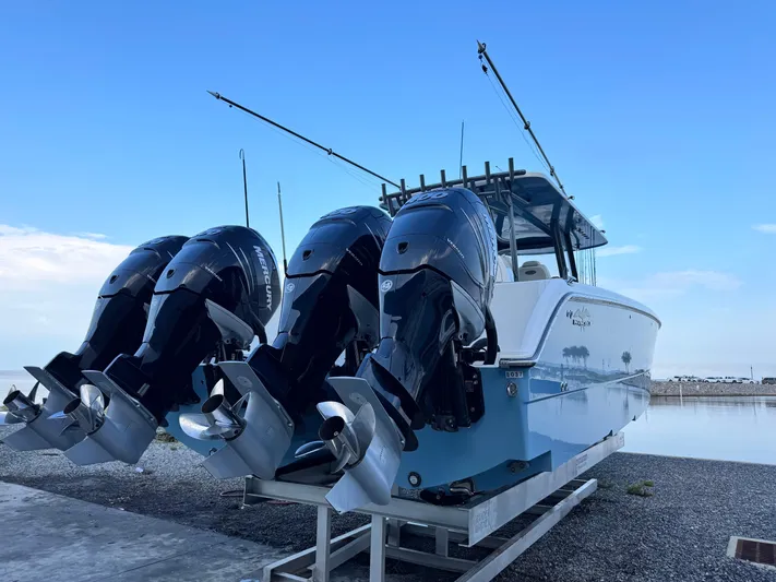  Yacht Photos Pics 2022 Invincible 40 Catamaran with triple Mercury outboard engines on a trailer by the water.