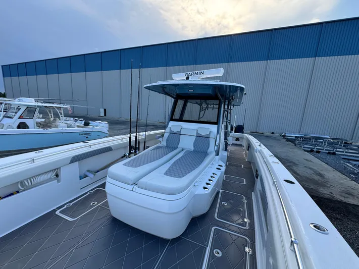  Yacht Photos Pics 2022 Invincible 40 Catamaran with spacious deck and seating, docked near a large warehouse.