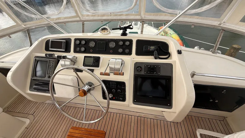 Destination Yacht Photos Pics 1995 Ocean Alexander 546 helm with navigation instruments and steering wheel, docked at marina.