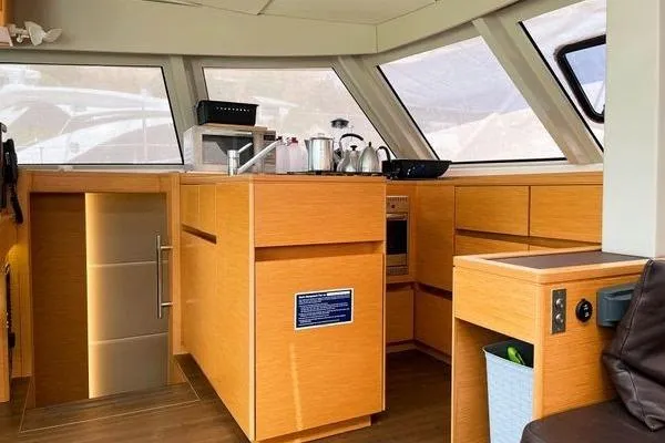 Susie Sea Yacht Photos Pics Modern kitchen interior of 2019 Nautitech 46 Open catamaran with wooden cabinetry and appliances.