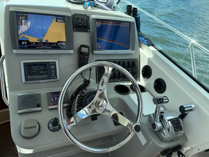 Fortunate Son Yacht Photos Pics Control panel of a 2013 Boston Whaler 315 Conquest with navigation screens and steering wheel.