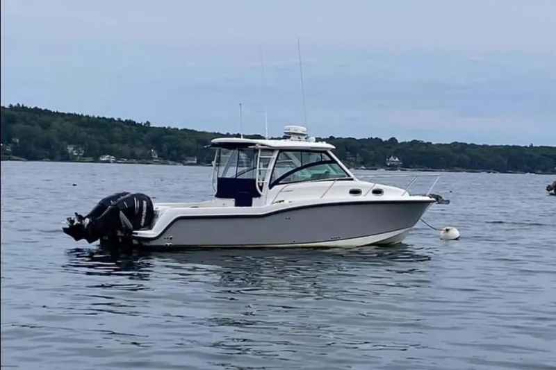 Fortunate Son Yacht Photos Pics 2013 Boston Whaler 315 Conquest boat on calm lake waters.