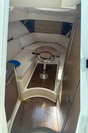 Fortunate Son Yacht Photos Pics Interior of 2013 Boston Whaler 315 Conquest, featuring cozy seating and wooden table.