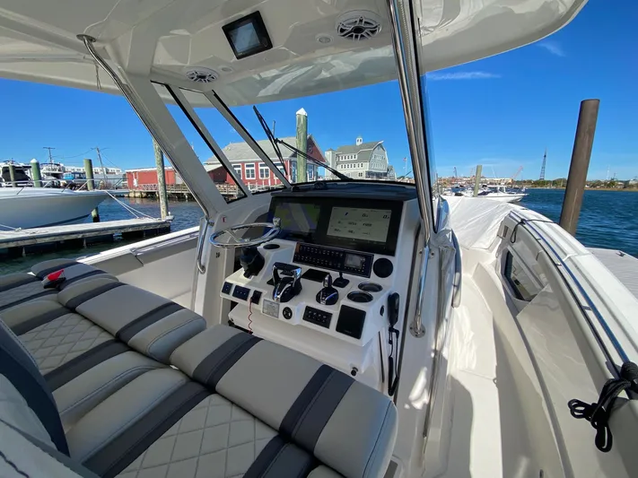  Yacht Photos Pics Interior view of 2022 Pursuit 378S boat with modern dashboard and waterfront background.