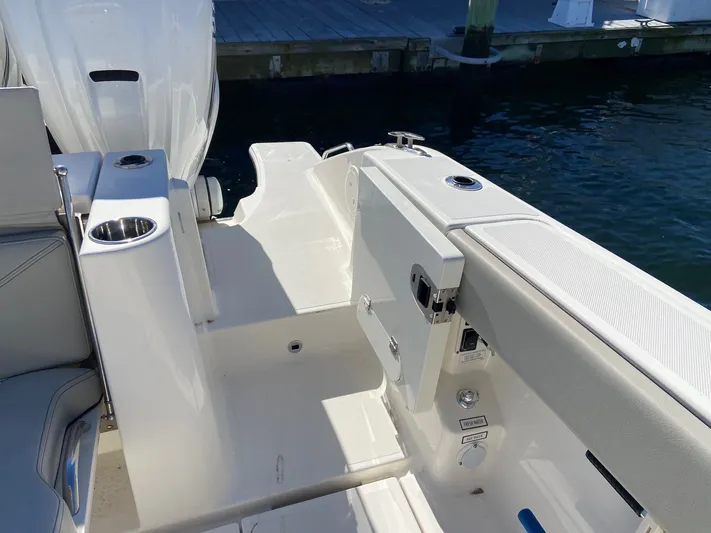  Yacht Photos Pics 2022 Pursuit 378S boat deck with seating and cup holder, docked by the water.