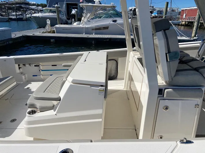  Yacht Photos Pics 2022 Pursuit 378S boat interior with seating and storage, docked at a marina.