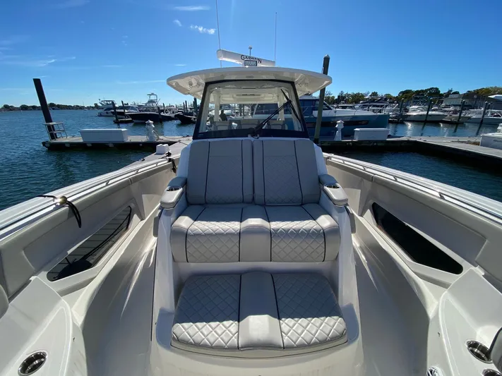  Yacht Photos Pics 2022 Pursuit 378S boat with luxurious seating at a marina.