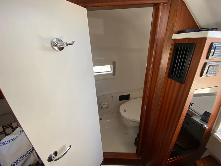  Yacht Photos Pics 2022 Pursuit 378S boat interior bathroom with wooden accents and modern fixtures.