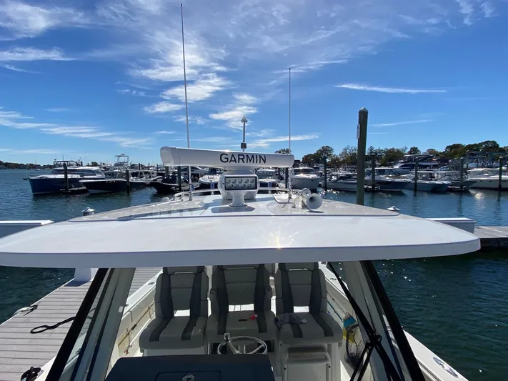  Yacht Photos Pics 2022 Pursuit 378S boat docked, featuring Garmin equipment under a clear blue sky.