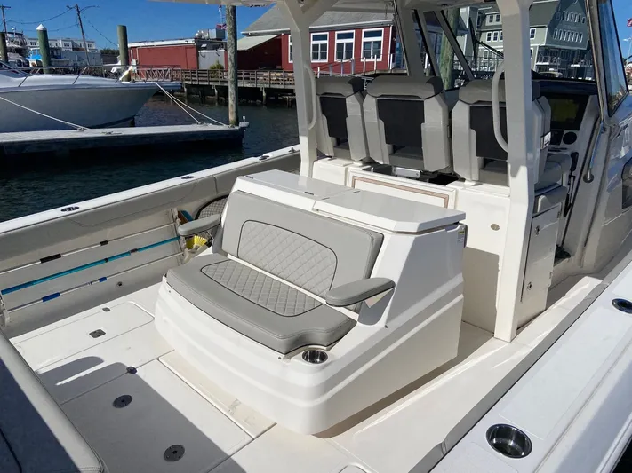  Yacht Photos Pics 2022 Pursuit 378S boat interior with seating and helm, docked at marina.