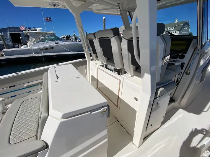  Yacht Photos Pics 2022 Pursuit 378S boat interior with seating and helm, docked at marina.