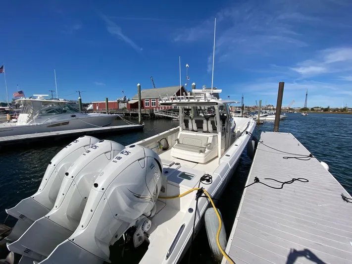  Yacht Photos Pics 2022 Pursuit 378S boat docked with triple outboard engines under clear blue sky.