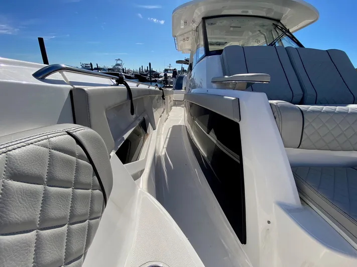  Yacht Photos Pics 2022 Pursuit 378S boat with luxurious seating and sleek design under clear blue sky.