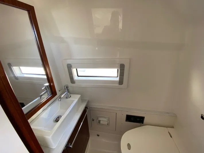  Yacht Photos Pics Modern bathroom interior of 2022 Pursuit 378S boat with sink, mirror, and window.