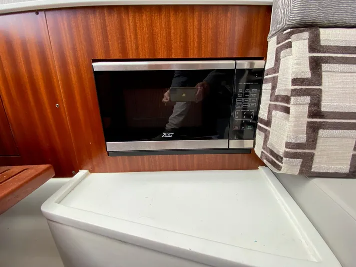  Yacht Photos Pics Microwave in 2022 Pursuit 378S boat interior with wood paneling and patterned upholstery.