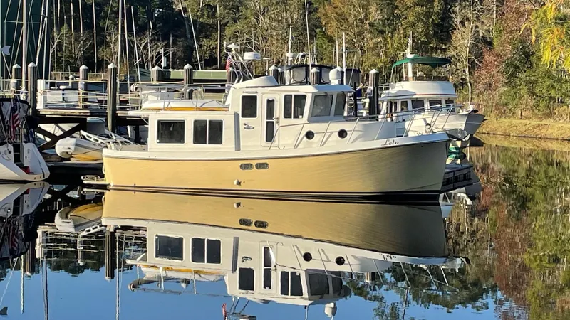 Leto Yacht Photos Pics American Tug 34, 2001 model, docked in a serene marina setting.