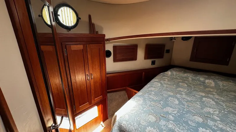 Leto Yacht Photos Pics Cozy cabin interior of 2001 American Tug 34 with wood paneling and bed.