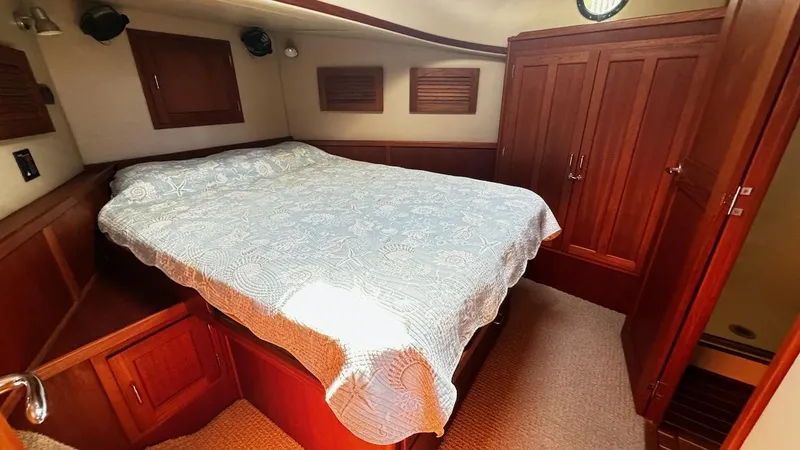 Leto Yacht Photos Pics Cozy cabin interior of 2001 American Tug 34 with wooden furnishings and a comfortable bed.