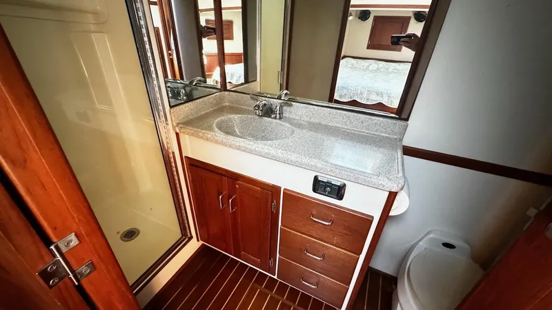 Leto Yacht Photos Pics Bathroom interior of 2001 American Tug 34 with wooden cabinetry and modern fixtures.