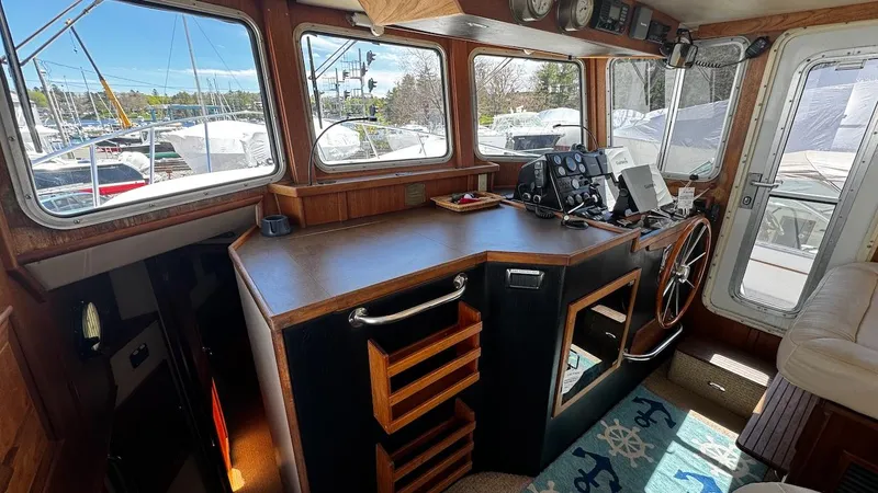 Leto Yacht Photos Pics Pilothouse interior of 2001 American Tug 34 with wooden helm and navigation equipment.