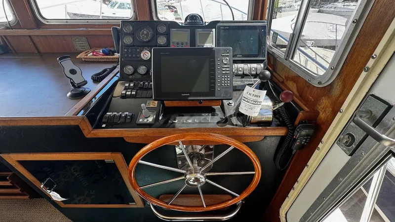 Leto Yacht Photos Pics Pilot house of 2001 American Tug 34 with navigation equipment and wooden steering wheel.
