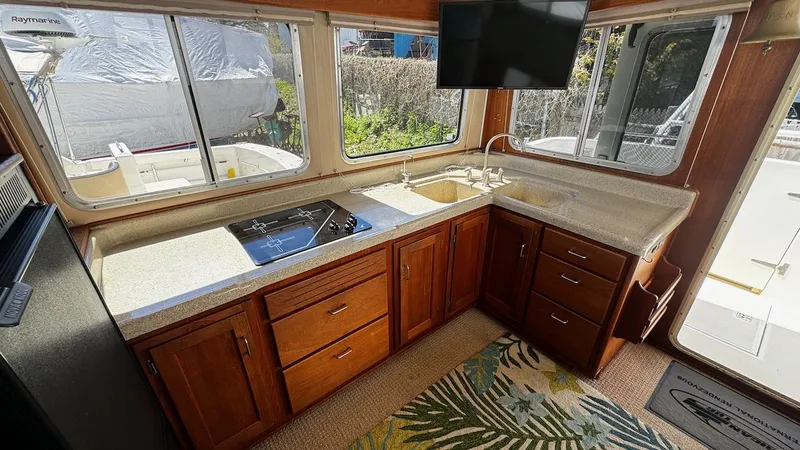 Leto Yacht Photos Pics Interior of 2001 American Tug 34 with kitchen, stove, sink, and large windows.