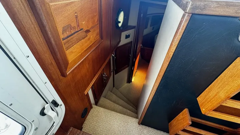 Leto Yacht Photos Pics Interior stairs of a 2001 American Tug 34, featuring wood paneling and carpeted steps.