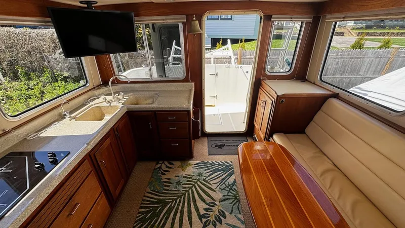 Leto Yacht Photos Pics Interior of 2001 American Tug 34, featuring kitchen, seating, and outdoor access.