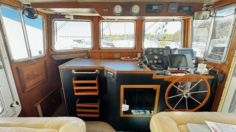 Leto Yacht Photos Pics Pilothouse of 2001 American Tug 34 with navigation equipment and wooden steering wheel.