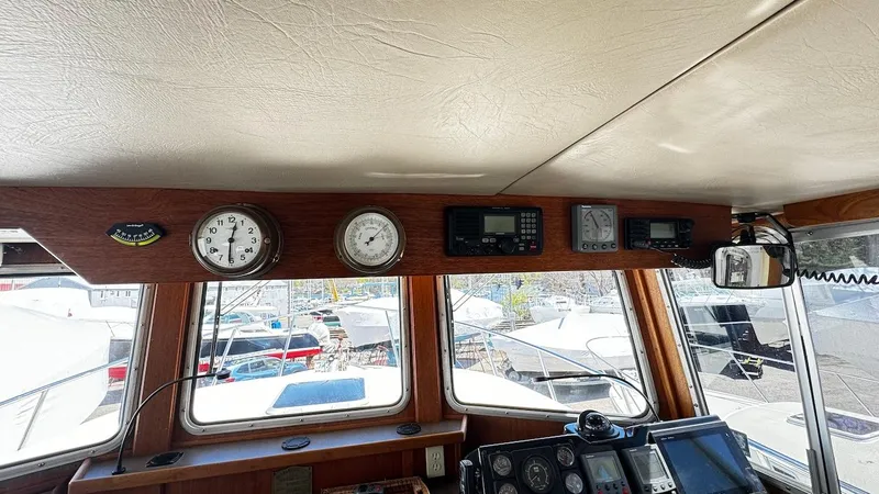 Leto Yacht Photos Pics Pilothouse interior of 2001 American Tug 34, featuring navigation instruments and windows.