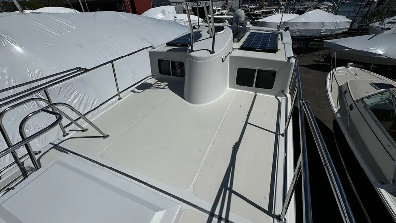 Leto Yacht Photos Pics American Tug 34 (2001) boat deck with railing and solar panels in marina.