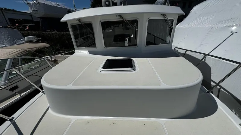 Leto Yacht Photos Pics American Tug 34, 2001 model, boat deck with hatch and railing, docked in marina.